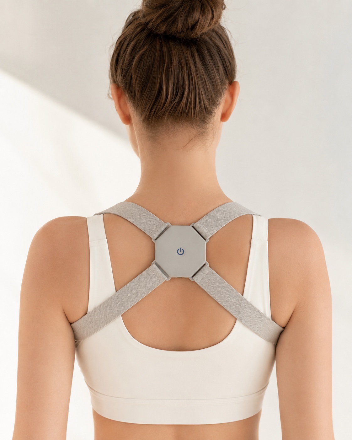Macro do sensor eletrônico minimalista do Smart Posture Corrector em uso ergonômico.