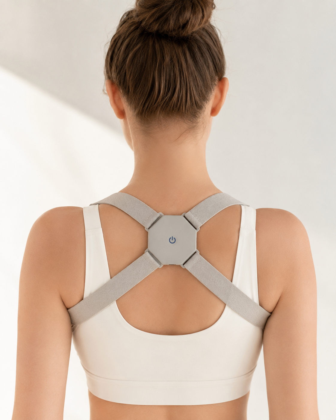 Macro do sensor eletrônico minimalista do Smart Posture Corrector em uso ergonômico.